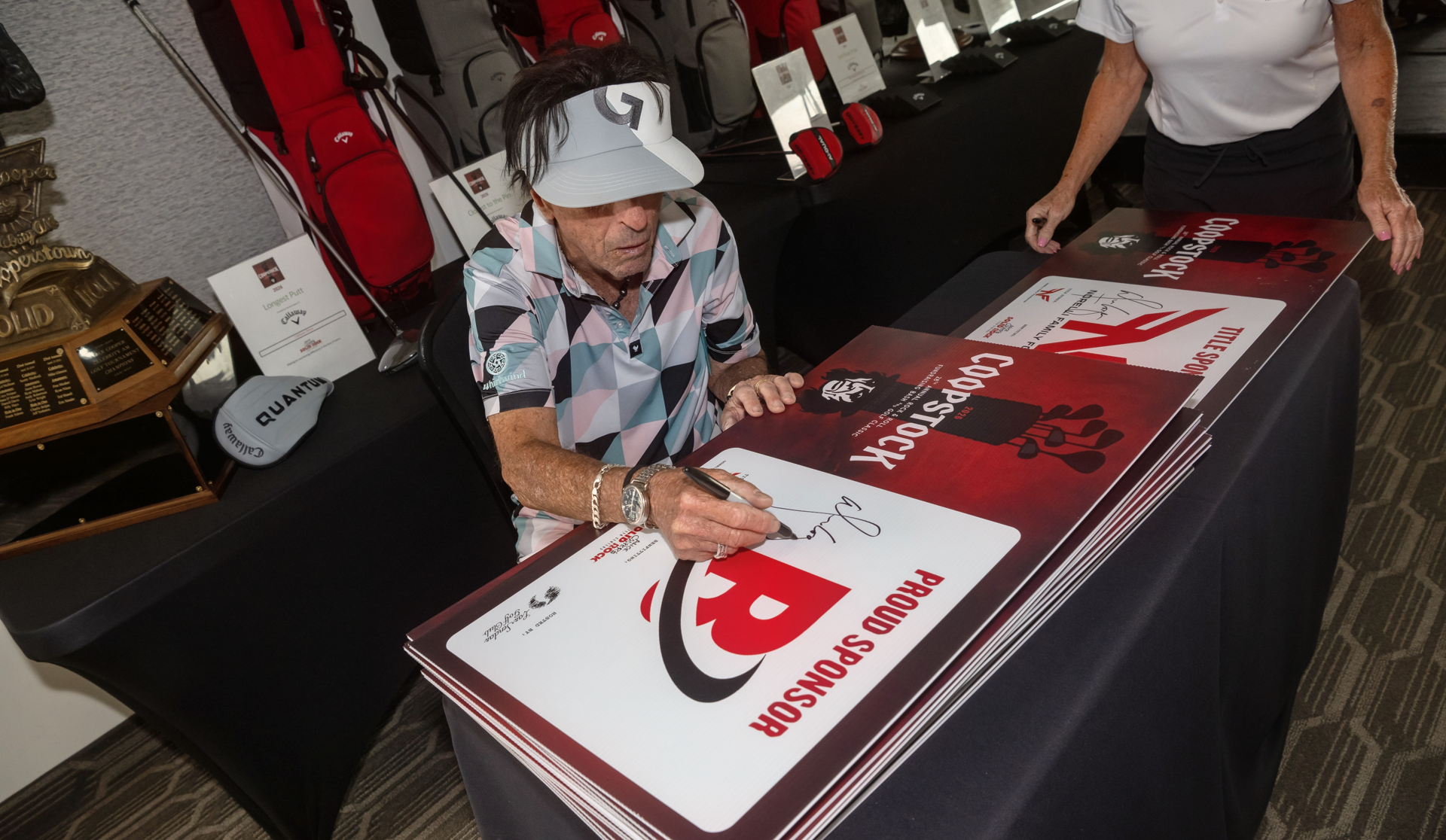 Alice Cooper signing a Coopstock Proud Sponsor sign